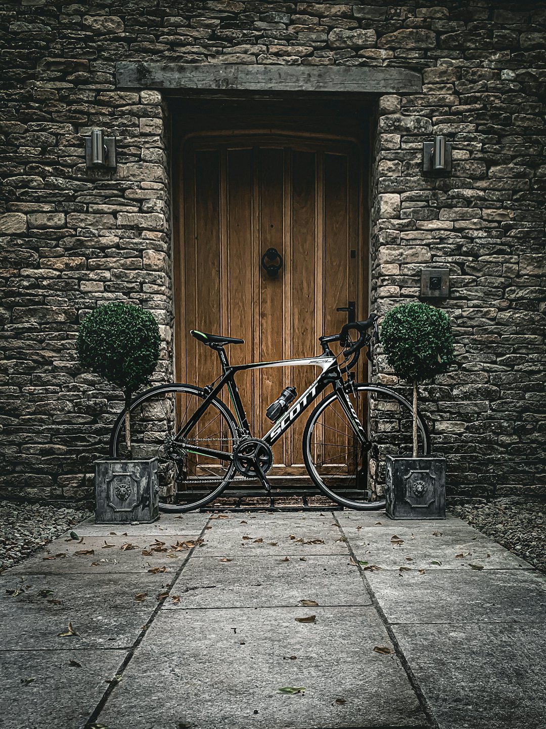 Bicicletta da corsa in bianco e nero parcheggiata fuori da un edificio in pietra.